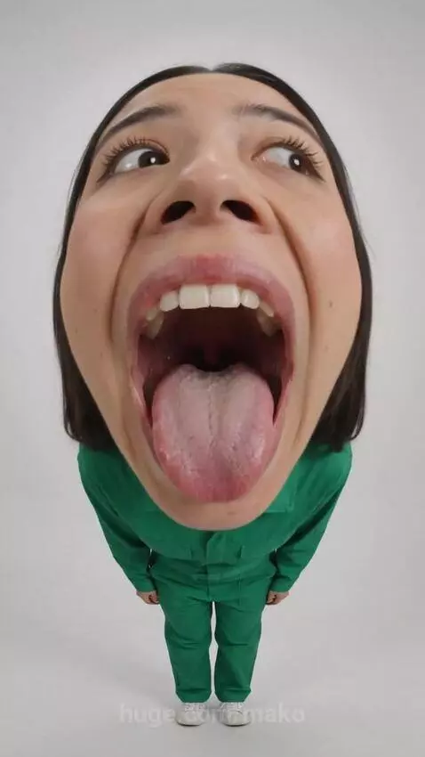 Woman in green jumpsuit with pigtails, mouth open, with a Loudmouth candy wrapper appearing on her tongue.