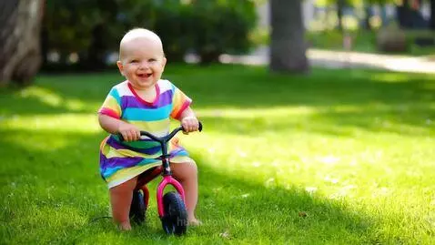 A joyful video of a baby happily riding a toy bicycle in the... by talha
