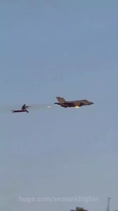 Animated man on a flying carpet firing a rifle at a distant F-35 fighter jet in a desert sky.