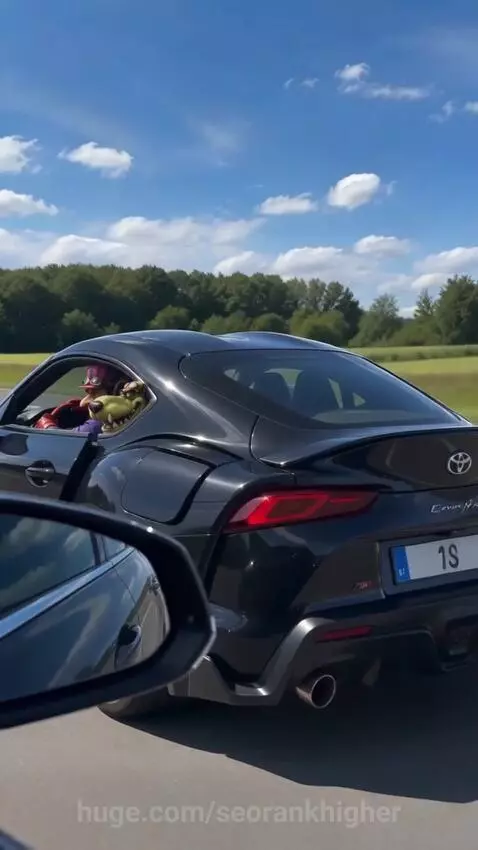 Black Toyota Supra with a jet engine accelerating on a highway, with puppets inside.