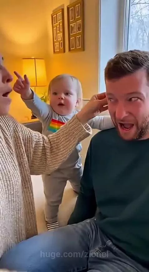 Toddler girl looking serious, pointing finger at her dad, demanding an apology.
