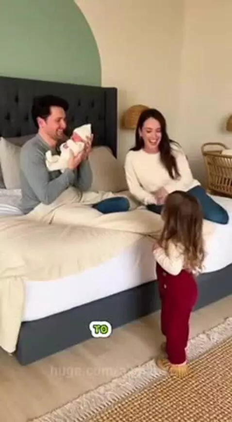 Toddler looking confused and jealous at a new baby sibling.