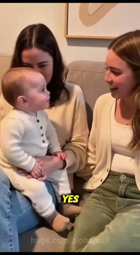 Woman holding a baby on her lap, both women laughing as the baby's voice asks for a phone number.
