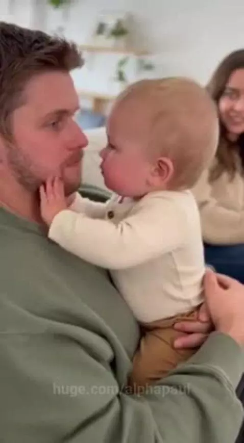 Baby playfully touching dad's face, then demanding he shout 'Okay!' louder.