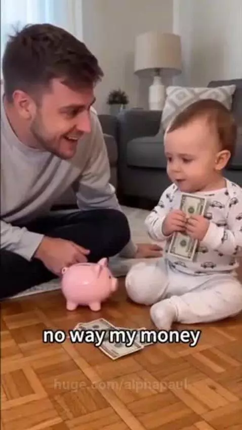 Man sitting on floor asks baby for money, baby holds cash and refuses, man looks busted.