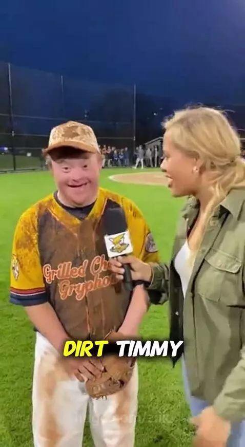 Baseball player Timothy covered in dirt smiles during an interview on the field.