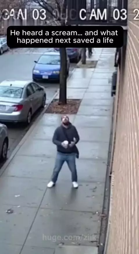 Man in a blue shirt catches a baby falling from a building, holding it safely in his arms.