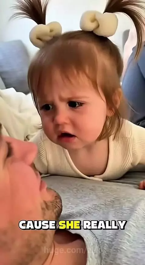 Young girl with pigtails and bows looking upset, lying face-to-face with a man, claiming she is prettier than her mom.