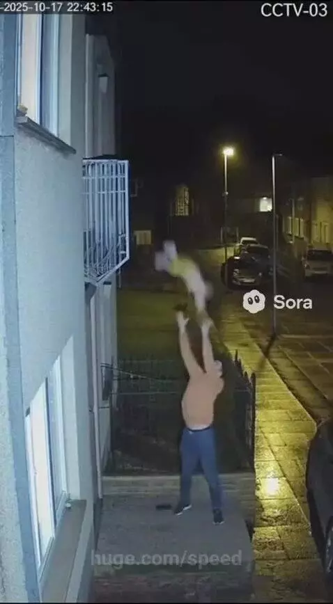 Man on ground level catches a baby dropped from a balcony at night.