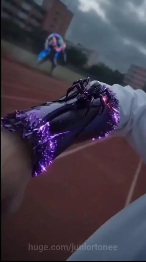 Man with white hair and glasses manifesting glowing purple energy and tentacle-like powers on a running track.