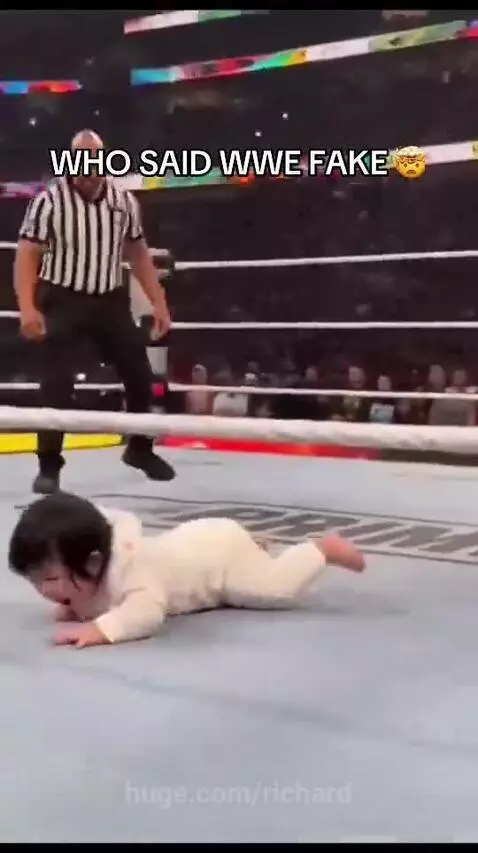 Baby in wrestling ring performing a move on a fallen wrestler, text overlay 'WHO SAID WWE FAKE'