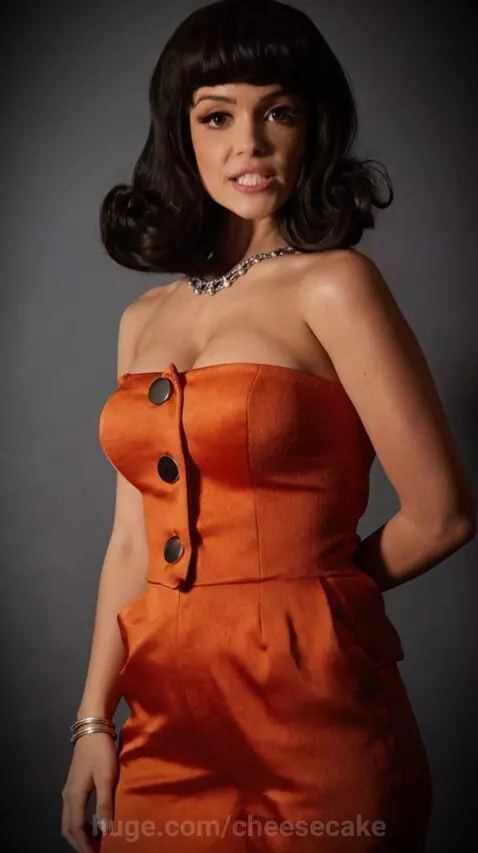 Woman in orange top tells a joke about chickpeas and garbanzo beans with a playful expression.