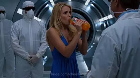 Woman in blue dress holding Fanta bottle, distressed as hazmat figures restrain her in a sterile corridor.