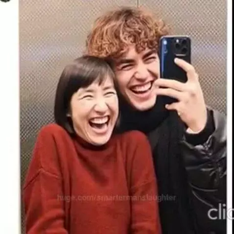 Man and woman taking a selfie in an elevator, woman's face has funny digital filters applied.