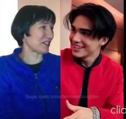 A young man and older woman smiling and dancing together, sharing a joyful moment.