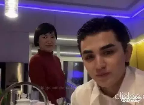 Couple smiling and dancing in a modern kitchen with blue and yellow LED lighting.