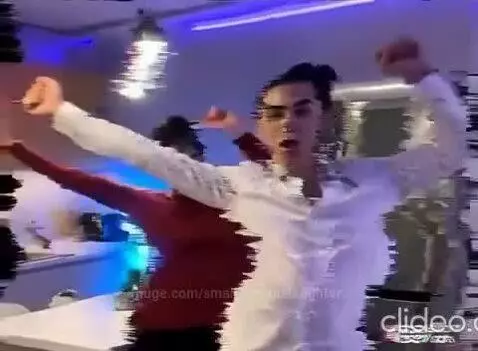 Couple dancing and kissing in a kitchen with TikTok visual effects like confetti and musical notes.