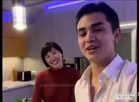 Couple smiling and kissing in a modern kitchen, dancing to celebrate 'black and white love'.
