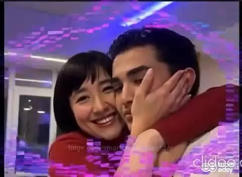 Young couple embracing and smiling, surrounded by animated hearts and sparkles, with upbeat music.