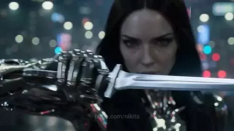 Female humanoid robot with metallic skin fights a skeletal robot with red eyes on a rainy city street at night.