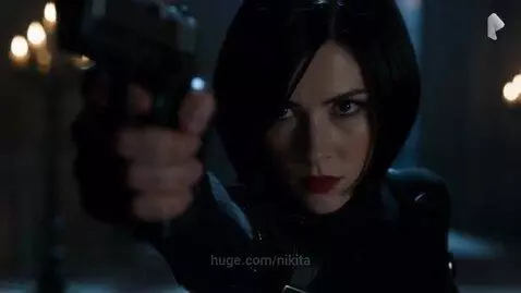 Ada Wong in a black tactical suit points a handgun at a tall, dark, hooded figure with glowing red eyes.