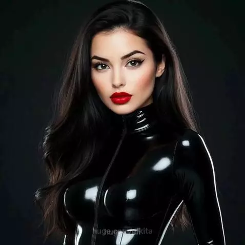 Woman with dark wavy hair and red lipstick in a black latex suit poses with a Venom character.