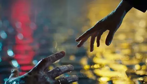 Man lying on wet street in rain, distressed. Woman in leather jacket approaches him.