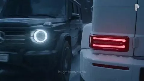Two Mercedes-Benz G-Wagens in a high-speed chase on a dark, snowy mountain road at night.