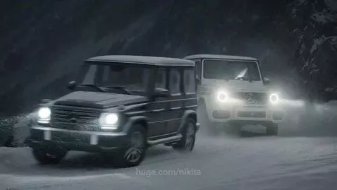 Two Mercedes-Benz G-Wagens driving at high speed on a narrow, snow-covered mountain road with steep drops.