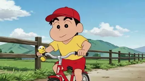 Crayon Shin-chan happily riding a red bicycle with a yellow duck toy on the handlebars, in a scenic outdoor setting.