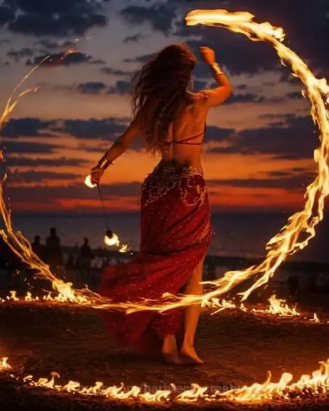 Woman in golden dress with glowing effects during sunset, evoking Summer Solstice magic.