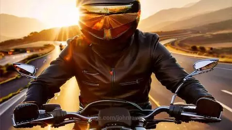 Motorcyclist in black leather jacket riding on a highway during a vibrant sunset.
