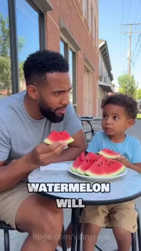 A young boy looks up at his pregnant mother's belly, confused about watermelon seeds.