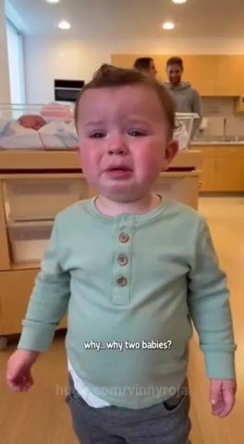 Upset toddler crying, asking about the new baby in the hospital room.