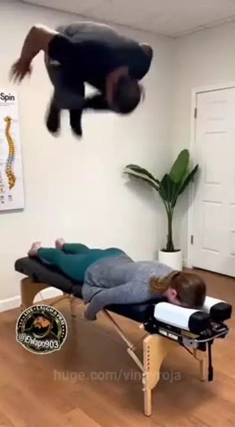 Man jumps on woman's back during chiropractic adjustment, causing the table to break.
