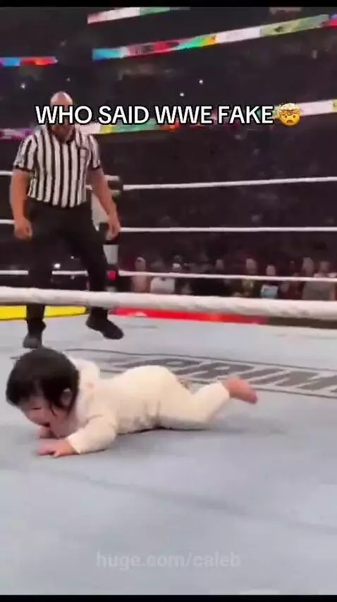 Baby in wrestling ring with The Rock, appearing to slap his hand and jump on him.