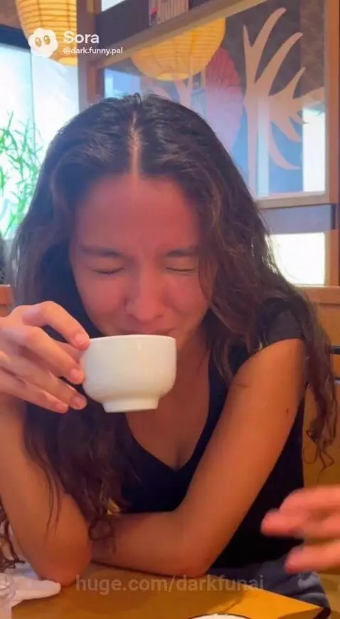 Man animatedly telling a story at a restaurant table covered in edamame pods, woman listening and laughing.