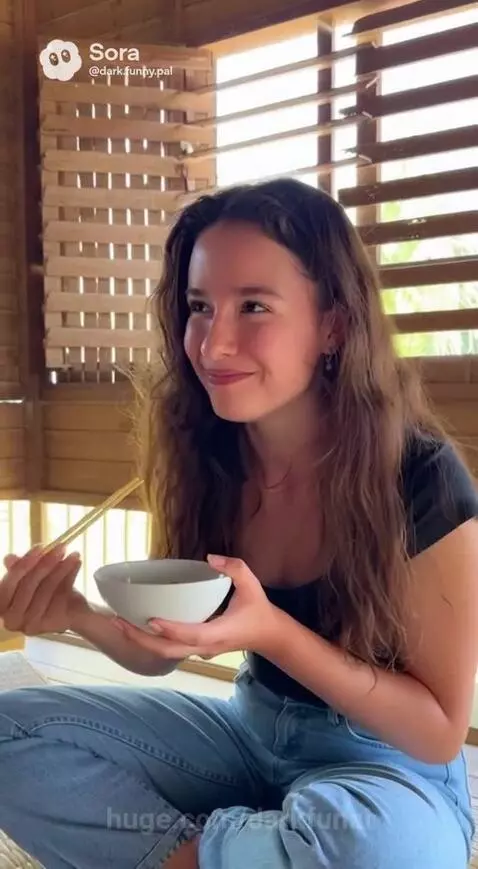 Elderly woman, man, and younger woman sharing a meal and laughing in a wooden room.