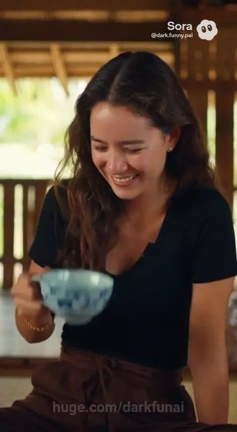 Two women in a rustic setting, one telling a story animatedly, the other listening with a smile.