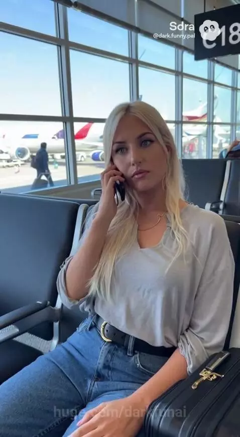 Man on phone looking concerned, woman in airport waiting area looking at planes.