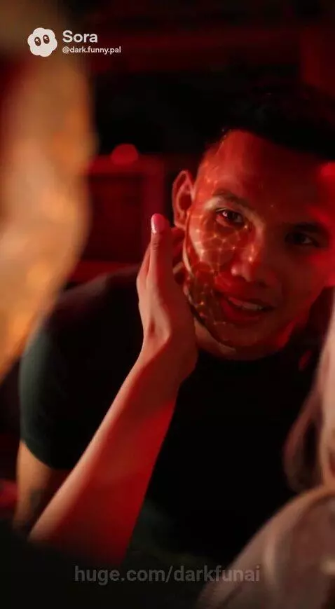 Man with glowing web-like pattern on face, woman crying, dramatic red-lit scene.