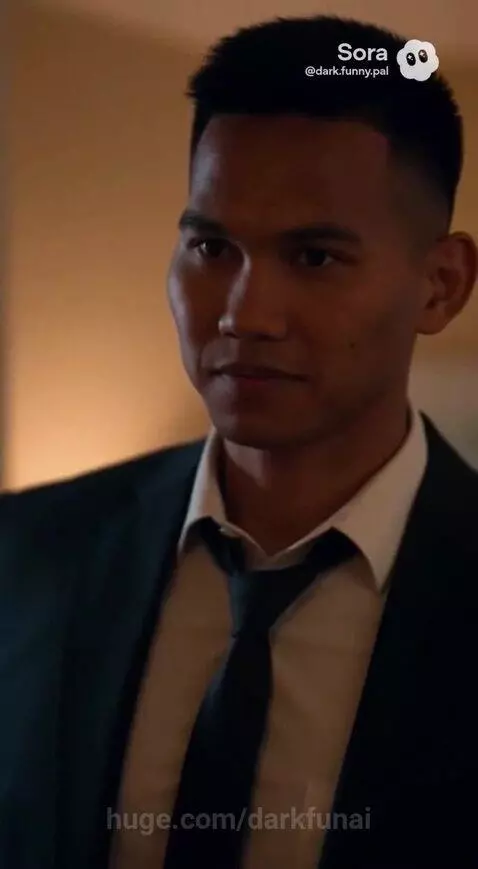 Man in suit asks man in hoodie about Fany's office location in a home setting.