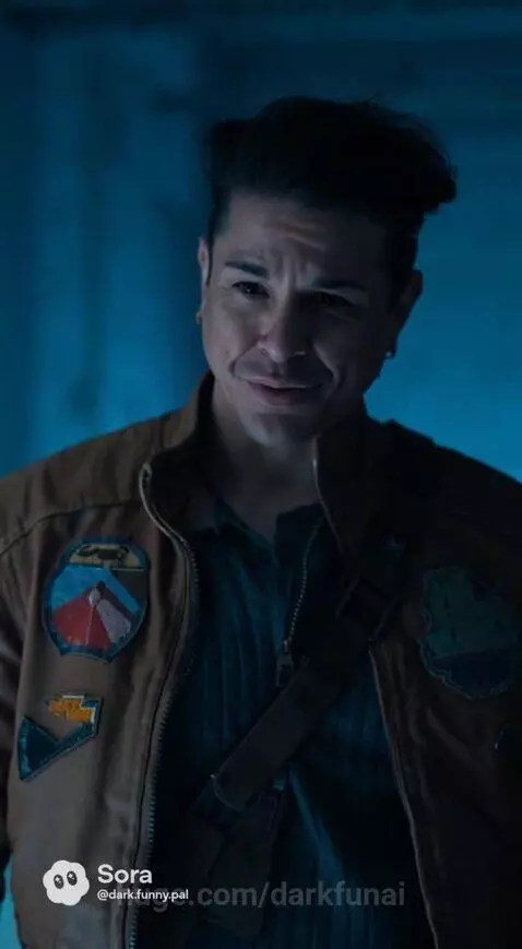 Paige emerges from a futuristic stasis pod, met by a man in a dimly lit, blue-toned room.