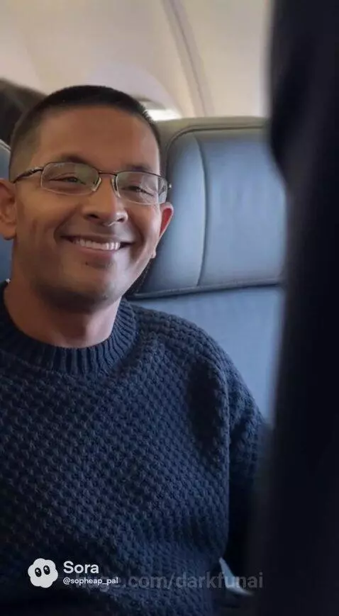 Flight attendant in uniform serving a drink to a passenger on an airplane.