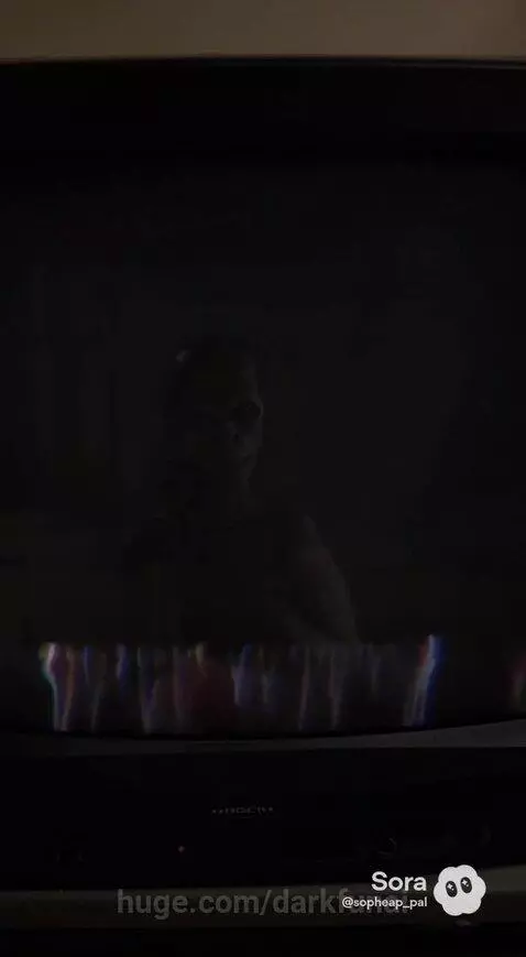 A distorted, Gollum-like creature with a wide grin presses against a TV screen, then crawls towards a woman.