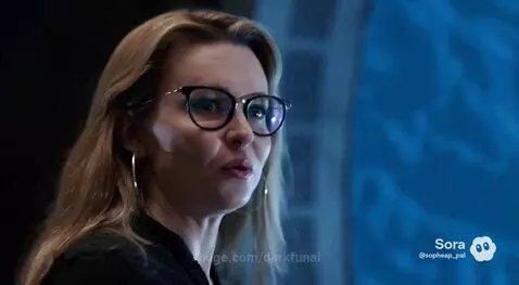 Woman in black with glasses jumps into a swirling blue portal as a man in a robe watches.