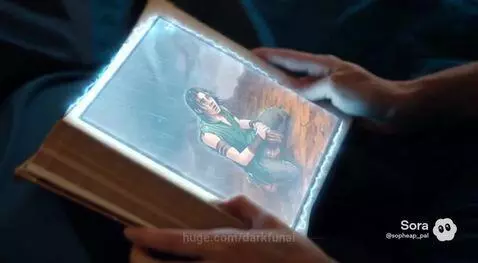 Close-up of a glowing animated illustration of a distressed young man in a green tunic within an open book.