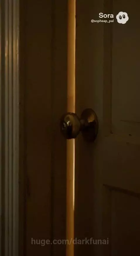 Woman in dimly lit room with US Marine Corps flag, looking sad while holding a suitcase.