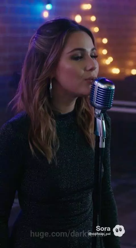 A band performs live on stage with string lights and a neon "HIGHWIRE" sign. A man sings and plays guitar.