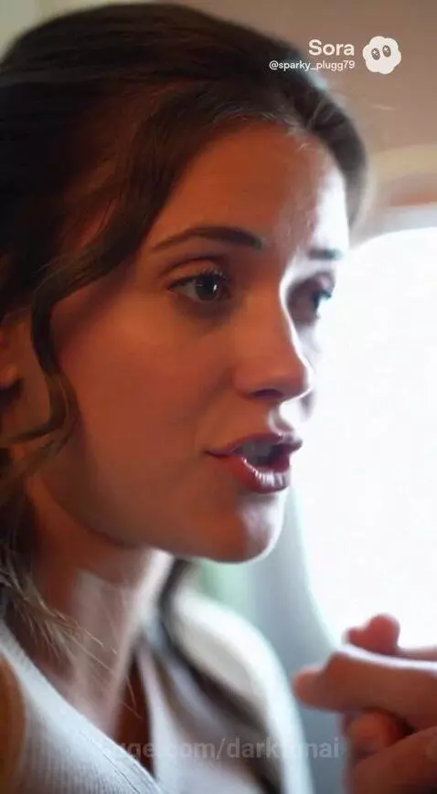 Young couple on an airplane with soda and snacks, sharing exciting job offer news.